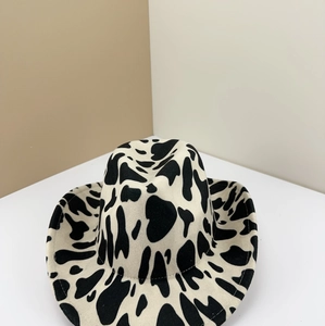 Detailed macro view of black and white cow print wool cowboy hat with retro felt texture