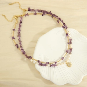 Double-layered necklace with purple gravel, freshwater pearls, and gold sun pendant