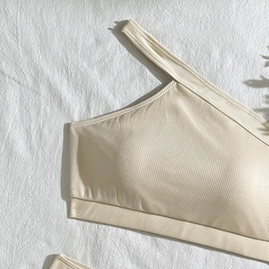 Detailed close-up of cream ribbed texture on a one-shoulder bikini top with high elasticity