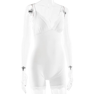 Detail shot of white bodysuit with intricate lace trim on the bust and leg openings