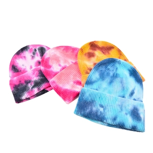 Detail showing four vibrant tie-dye ribbed knit beanies in various colorful patterns