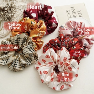 Detail of assorted satin scrunchies featuring heart, floral and houndstooth patterns