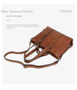 Detail of brown soft leather tote bag showing adjustable strap and front zipper pocket