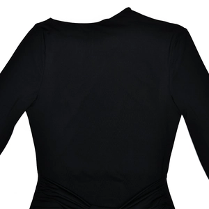 Détail d'une robe noire cintrée avec décolleté asymétrique et texture froncée à la taille