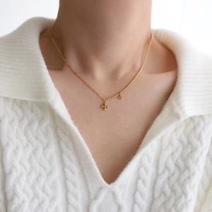 Minimalist 18K gold plated beaded cross star pendant necklace worn on a model