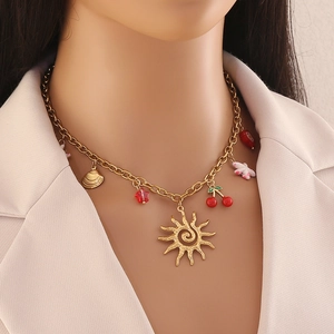 Gold stainless steel necklace with sun, cherry, and floral charms on a model