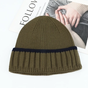 Detailed knit texture of olive green and navy striped winter beanie on white background