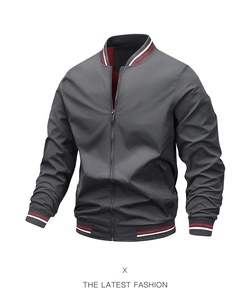 Close-up of grey bomber jacket showing red and white striped ribbed collar and metal zipper