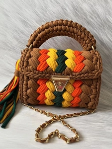 Handmade crochet striped handbag with brown base, colorful braids, and gold chain strap
