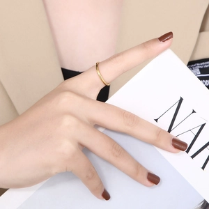 Minimalist slim gold titanium steel ring worn on index finger for elegant layering look