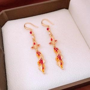Macro view of gold koi fish earrings with red enamel tail and bead details