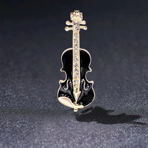 Detail of cello brooch with golden alloy base, black enamel, and sparkling rhinestones