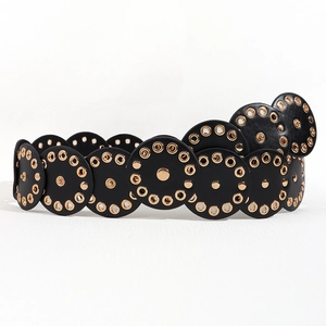 Detail of black leather panels with golden grommets and central metal rivets on belt