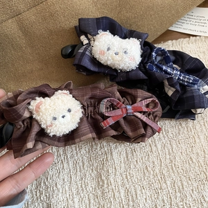 Détail de pinces à cheveux à carreaux rétro avec ours en peluche et nœud sur fond texturé