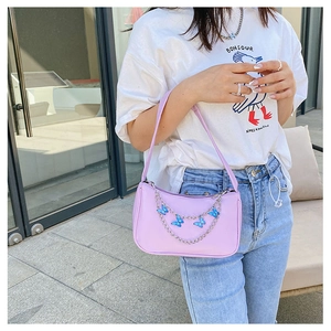 Close-up of light purple underarm bag featuring silver chain and blue butterfly charms