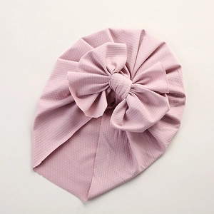 Detail of pink baby turban hat with large bow decoration and ice silk textured fabric