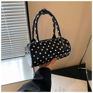 Close-up of black polka dot Boston handbag with glossy finish and double handles