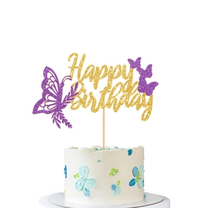 Detail of gold and purple butterfly Happy Birthday cake topper on a white cream cake