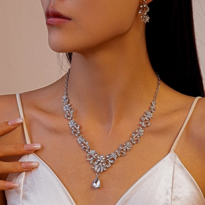 Detail of leaf and flower bridal necklace set with a large teardrop rhinestone pendant