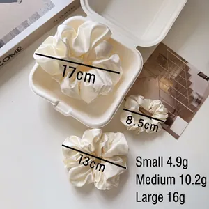 Three sizes of cream satin scrunchies set including small, medium and large hair ties