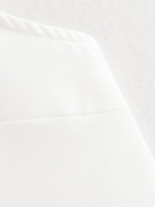Macro detail of white ruffled top fabric showing high-quality stitching and texture