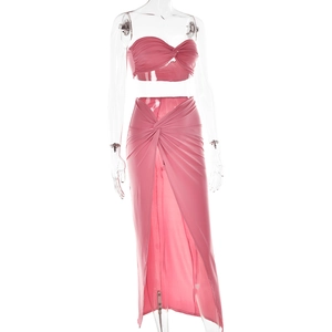 Detail view of pink two-piece set featuring a twisted crop top and high-slit maxi skirt
