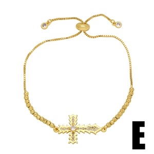 Macro shot of gold-plated cross bracelet with cubic zirconia inlay and slider chain