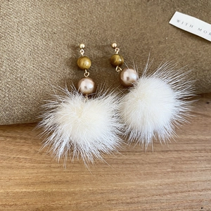 Detail von eleganten Ohrringen mit Tigerauge, Perlen und weißen weichen Plüsch-Pompons