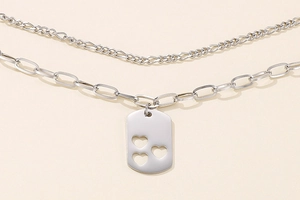 Close-up of double layer silver necklace with paperclip chain and heart pendant