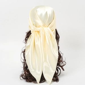 Macro view of champagne satin square scarf texture with silky metallic luster on mannequin