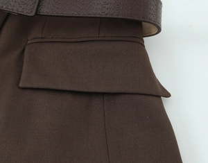 Detailed view of dark brown twill fabric with embossed leather belt and pocket