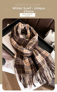 Détail d'une écharpe d'hiver à carreaux avec pompons marron et orange