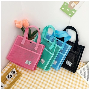 Close-up of four colorful mesh tote bags with Fashion Bag tags on a checkered tablecloth