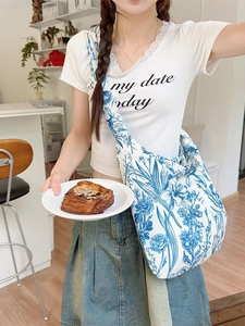 Blue floral canvas hobo bag with vintage porcelain pattern shown in a lifestyle scene