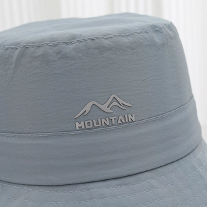 Close-up of gray mountain peak logo and breathable fabric on children sun hat