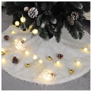 Detail of soft white faux fur Christmas tree skirt with festive lights and ornaments