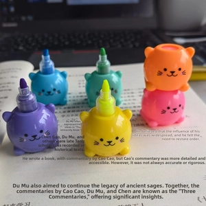 Set of 6 cartoon animal highlighters in pastel colors placed on an open book