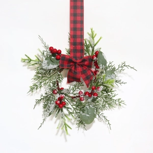 Mini Christmas wreath with eucalyptus, red berries, and snow coating on buffalo plaid ribbon