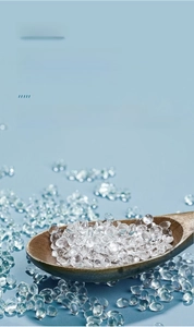 Macro shot of transparent food-grade silicone particles in a wooden spoon for baby toothbrushes