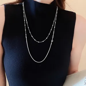 French luxury silver double-layer necklace with beads and snake chain on black sweater