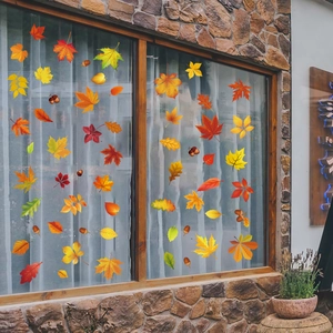 Detailed close-up of vibrant maple leaf and acorn static clings on glass window pane