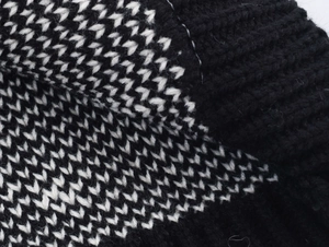 Close-up of black and white jacquard knit texture showing premium ribbed stitch detail