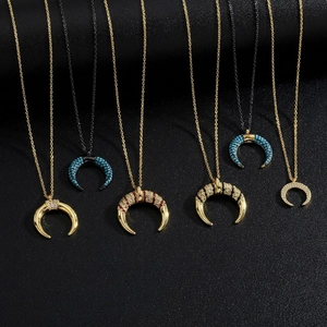 Detail showing moon-shaped necklaces with micro-set zircons and turquoise on black background