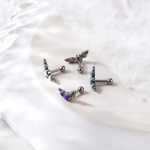 Polished stainless steel opal earrings with colorful stones on white stone background