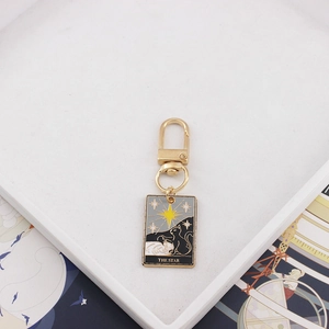 Close-up of The Star cat tarot card keychain with enamel finish and gold clasp