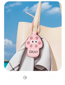 Pink mushroom-shaped magnetic hat clip with OKAY lettering hanging on a bag