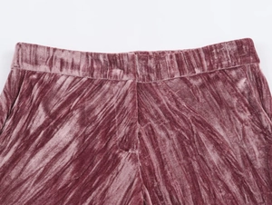 Detail of mauve pleated velvet trousers showing the elastic waistband and seam construction