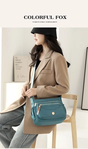 Close-up of dark teal waterproof nylon crossbody bag with multi-layer zipper pockets