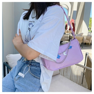 Detail of purple shoulder bag with silver metal chain and butterfly pendants decoration