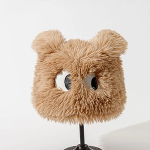 Detail of plush bucket hat with brown faux fur, cute bear ears and large cartoon eyes